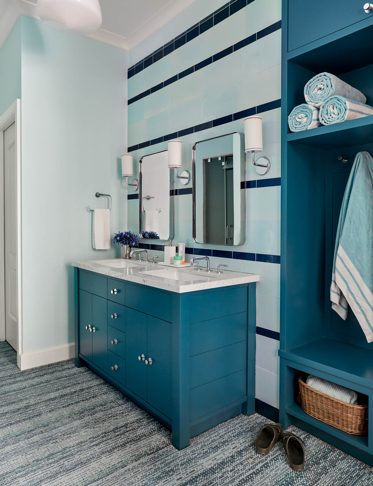 bathroom with dark blue vanity and shelving and lighter blue walls