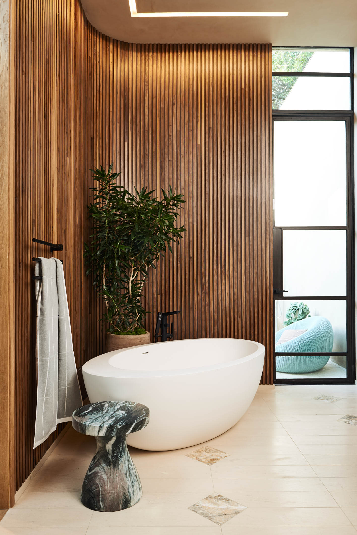 contemporary bathroom with a wood paneled wall around a white tub