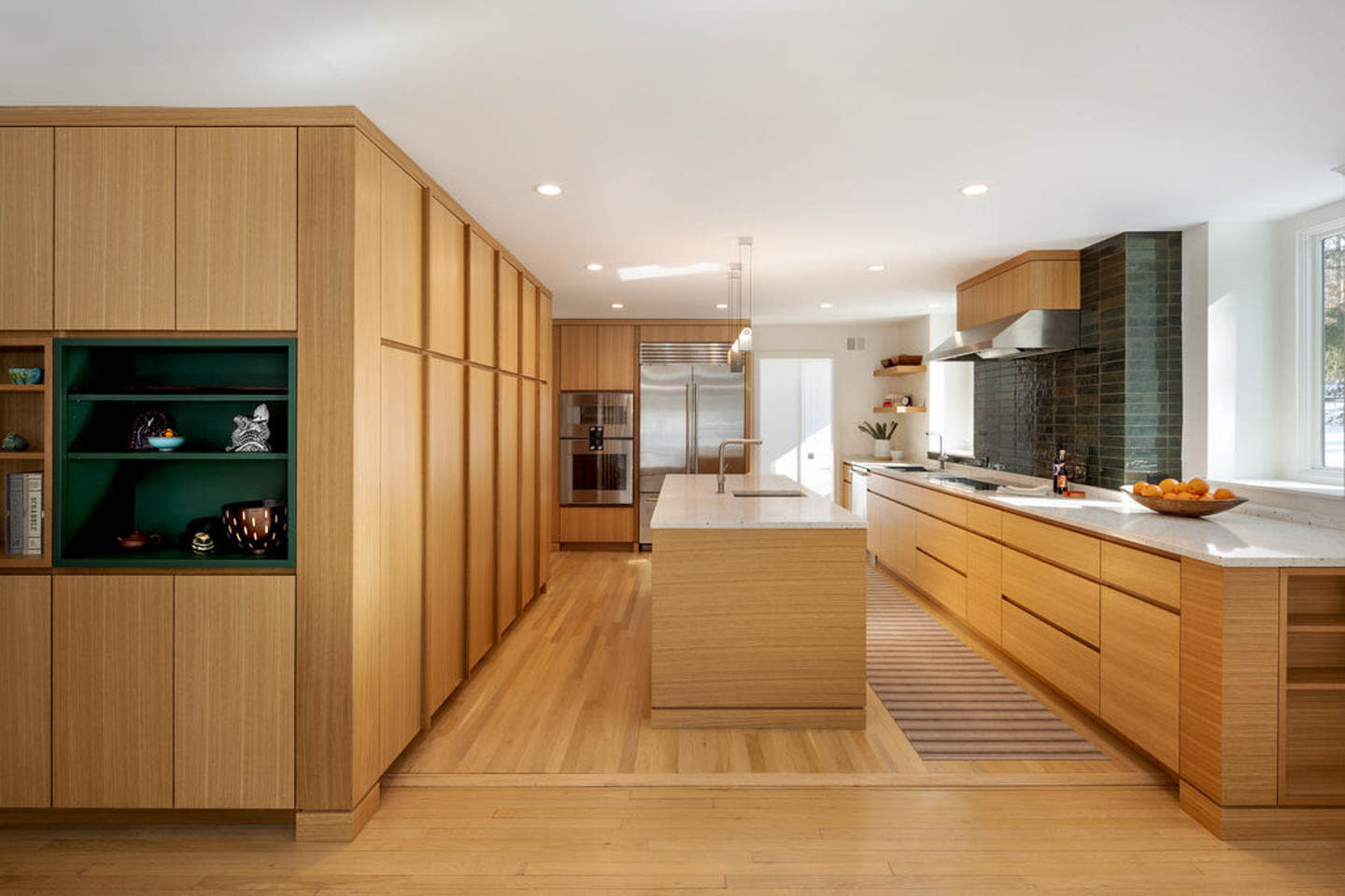 kitchen wrapped in light oak millwork on the cabinetry and walls