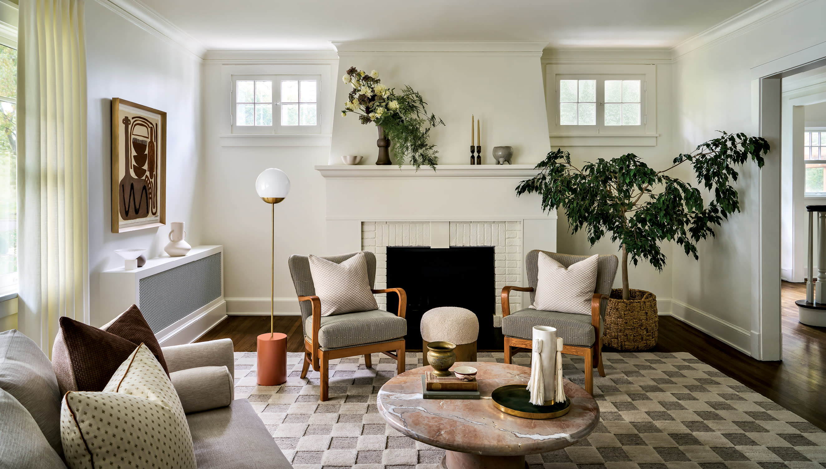 classic living room with a black fireplace surrounded by bright white painted brick and walls