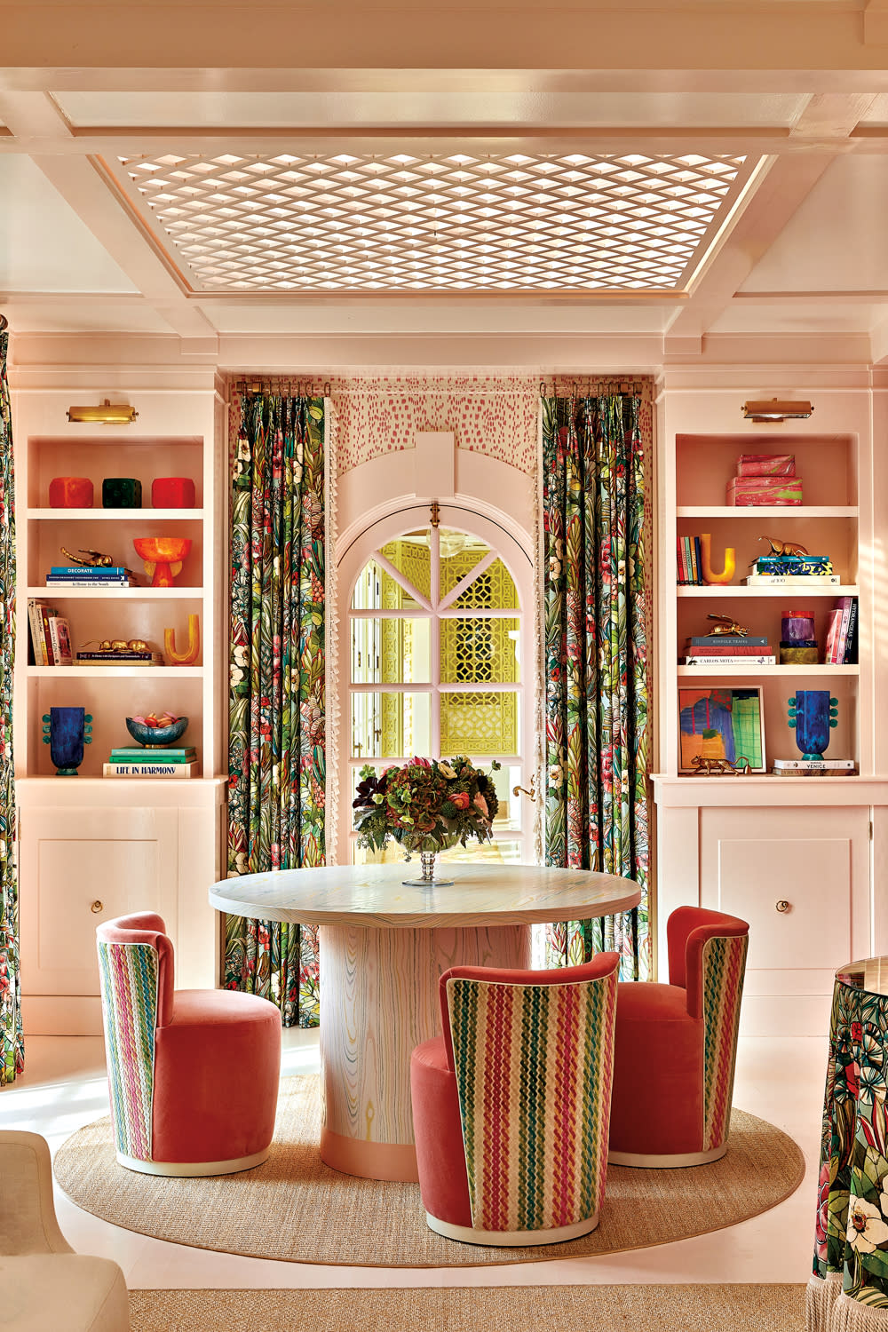 light pink living room with an arched window lined with floral print drapes