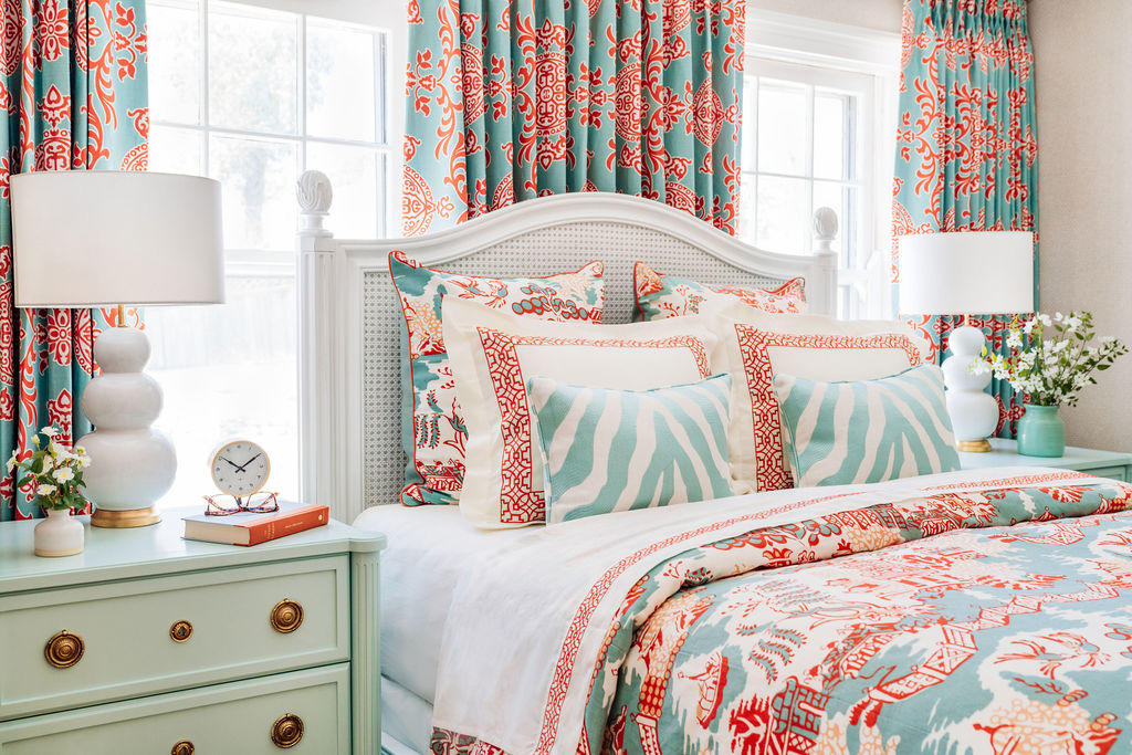 red and teal patterned bedding matches the drapes in this bold and cheery bedroom